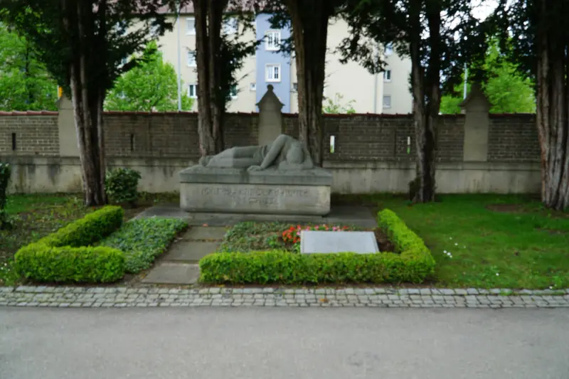 Kamienny pomnik z. leżącą postacią i. tablicą przed nim na cmentarzu Unter den Linden w. Reutlingen — Powiat Reutlingen